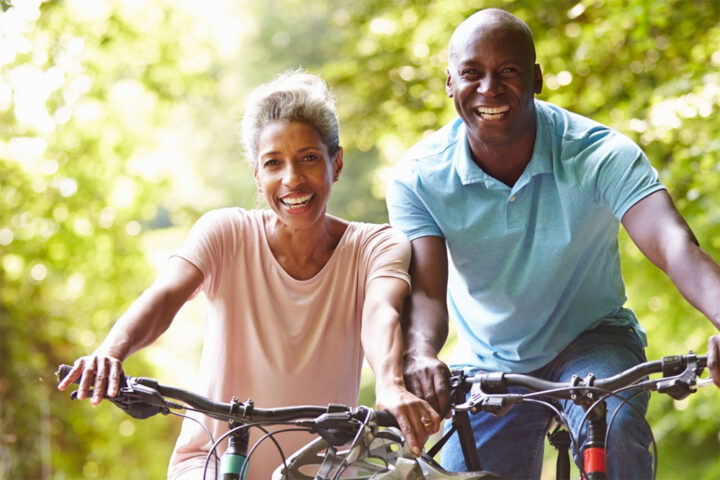 Two adults biking on a sunny day.